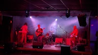a band performs on stage in a dark room