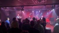 a crowd of people watching a band perform in a concert