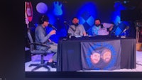 a tv screen showing a group of people sitting at a table
